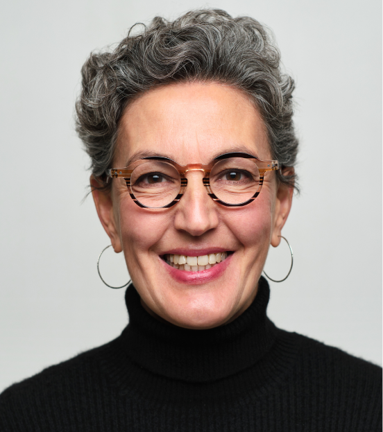 A portrait photo of a mature businesswoman in a black turtleneck smiling at the camera