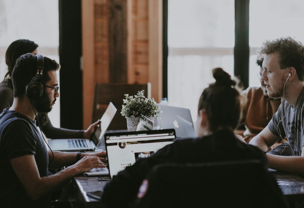 A group of young professionals sitting at a conference table working