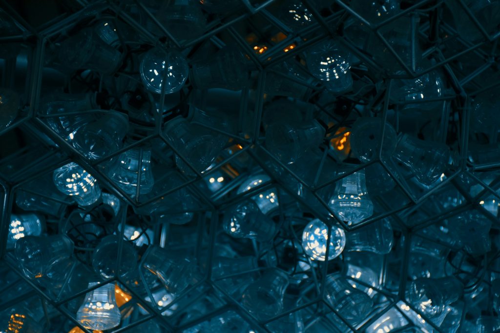 An abstract image of hundreds of lightbulbs in containers